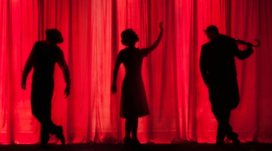 silhouettes against a red theater curtain silhouettes against theater curtain