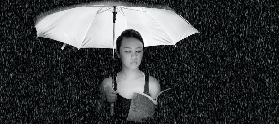 woman reading under umbrella