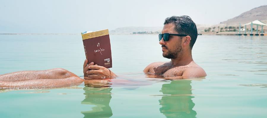 man reading in lake