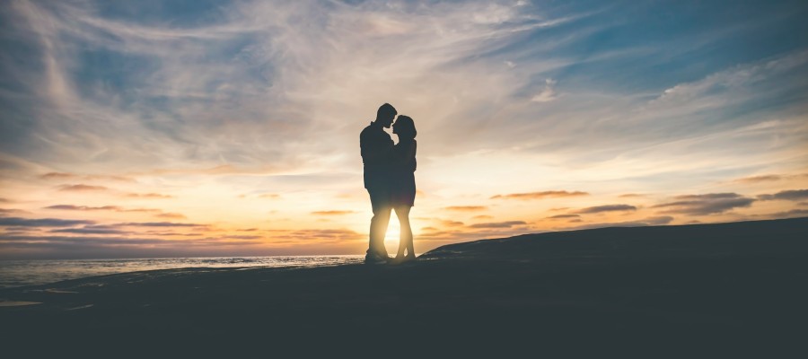 couple silhouetted against sunset couple silhouetted against sunset