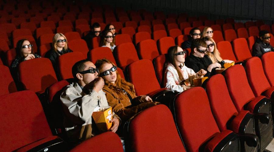 movie audience wearing 3-D glasses movie audience wearing 3-D glasses