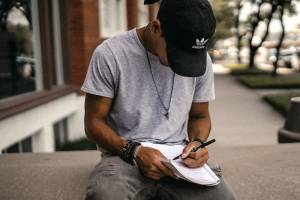 man writing outdoors to illustrate article on how to write a story