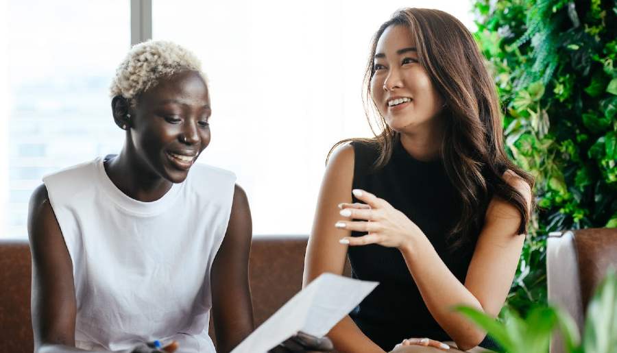 Two women are discussing a written document. two women talking