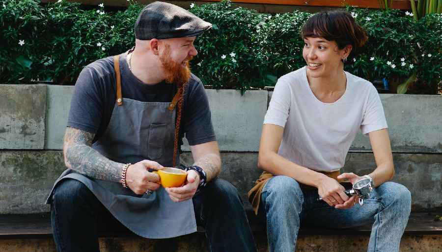 A man and woman sit together talking. man and woman talking, illustrating dialogue